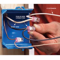 a person is plugging wires into an electrical box with the help of two hands