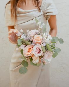 a woman holding a bouquet of flowers in her hands