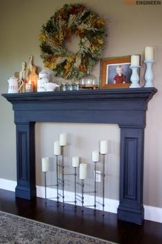 a mantel with candles and wreath on top