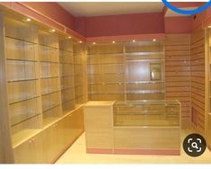 empty wooden shelves in a large room with pink walls and flooring on both sides