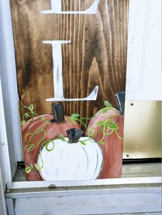 a painted pumpkin sitting on top of a window sill in front of a door