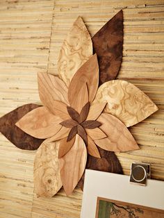 a wooden flower is mounted on the wall next to a picture frame with a ring in it