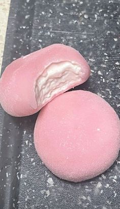 two pink donuts sitting on top of a counter