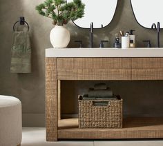 a bathroom vanity with two mirrors and a basket on the sink counter next to it