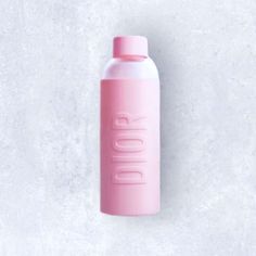 a pink water bottle sitting on top of a white wall