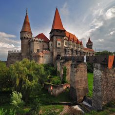 an old castle with red roof and towers