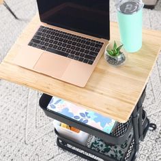 an open laptop computer sitting on top of a wooden table next to a drink can