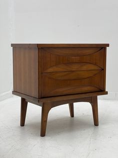 a wooden cabinet sitting on top of a white floor