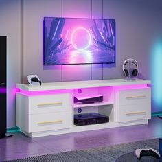 an entertainment center with headphones and a large television on it's stand in a living room