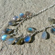 "This briolette necklace features thirteen faceted labradorite pear shaped gemstones. The deep flash of these gems is magnificent, dark blue and turquoise and they just keep flashing when you move. I would encourage you to view the video above to see these gems in motion. The gems are hand wired to a sterling chain with sterling wire. They are slightly graduated in size from 9.25mm to 10.8mm. The necklace is 18.5\" in length and closes with a magnetic clasp for easy on/off. Ships next business d Handmade Labradorite Drop Necklaces, Labradorite Drop Necklace With Gemstone, Labradorite Gemstone Drop Necklaces, Labradorite Drop Gemstone Necklaces, Adjustable Bohemian Labradorite Necklaces, Silver Labradorite Teardrop Necklace, Adjustable Nickel-free Labradorite Necklaces, Handmade Drop-shaped Labradorite Necklaces, Briolette Necklace