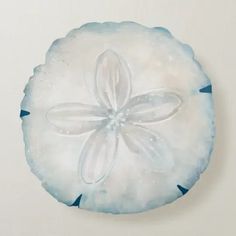 a blue and white sand dollarfish ornament hanging on the side of a wall