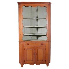 a wooden china cabinet with glass doors and drawers on the bottom shelf, in front of a white background