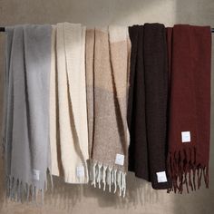 several different colors of towels hanging on a rack