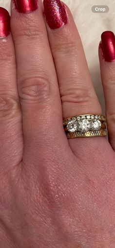 a woman's hand with a red manicured nail polish and a gold ring