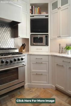 a kitchen with white cabinets and stainless steel stove top oven, built in shelving