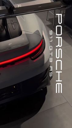 the back end of a gray sports car on display at an auto show with text reading porsche