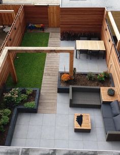 an overhead view of a patio with seating and tables in the center, surrounded by grass