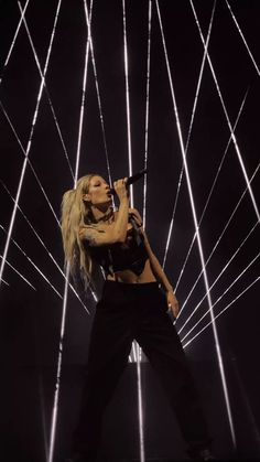 lady in black performing on stage with lights behind her