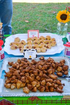 a table topped with lots of fried food next to sunflowers and other items