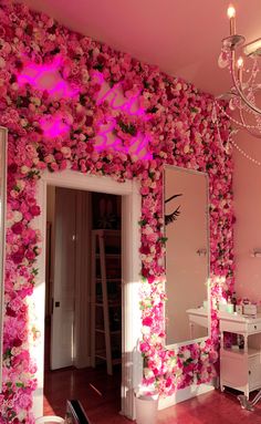 a room with pink flowers on the wall and a chandelier hanging from the ceiling