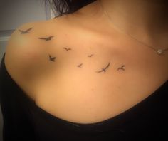 a woman's chest with birds flying in the air