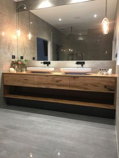 a bathroom with two sinks and a large mirror on the wall over it's counter