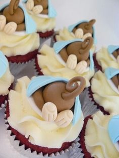 some cupcakes with icing on them are decorated like animals and people in blue hats