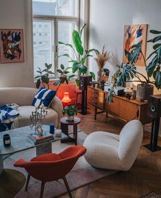 a living room filled with furniture and plants