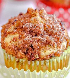 a close up of a cupcake with powdered sugar on top and an apple in the background