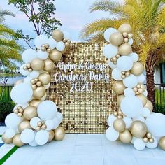 a gold and white wedding arch with balloons