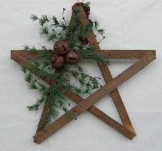 a wooden star decorated with pine cones and greenery is displayed on a white background