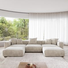 a living room with a large sectional couch and coffee table in front of the window