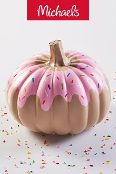 a pink and brown pumpkin with sprinkles on it