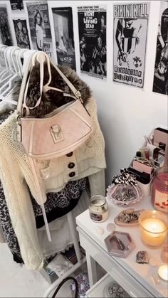 a white purse sitting on top of a table next to a wall covered in posters