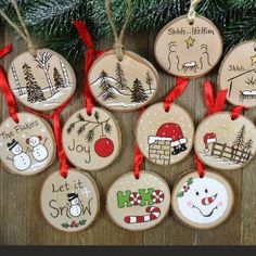 christmas ornaments hanging from a tree on a wooden table with red ribbon and snowmen