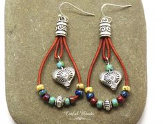 "Add a touch of bohemian flair to your accessory collection with these unique boho teardrop shaped leather earrings. The round leather cord is beautifully strung with your choice of seed bead colors, creating a vibrant and eye-catching look. A silver plated heart bead with a stunning southwestern design dangles elegantly in the center, adding a hint of charm to the overall design. Choose your preferred earring wires to personalize these stylish earrings to your liking. Perfect for adding a pop of color and personality to any outfit, these earrings are sure to become a favorite in your jewelry rotation. 𝐋𝐄𝐍𝐆𝐓𝐇: 2 1/2\" with hook earwires. Kidney wires will add about 1\". 𝐖𝐈𝐃𝐓𝐇: 1\" 𝐖𝐄𝐈𝐆𝐇𝐓: Each earring weighs 4.85 grams. A nickel weighs 5 grams. All jewelry is packaged read Leather Cord Jewelry, Cord Jewelry, Southwestern Design, Boho Leather, Round Leather, Stylish Earring, Heart Beads, Leather Earrings, Leather Jewelry