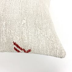 a white pillow with red thread on it