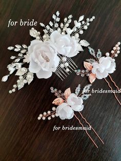 two bridal hair combs with flowers and pearls on them, sitting on a table