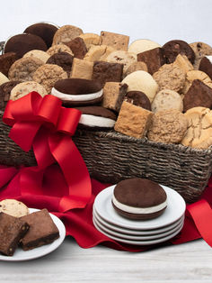 a basket filled with lots of different types of cookies and pastries next to plates