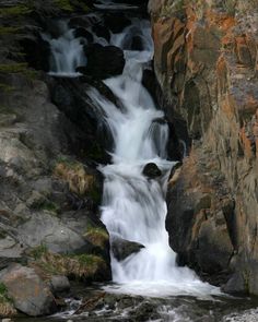 there is a waterfall in the middle of some rocks