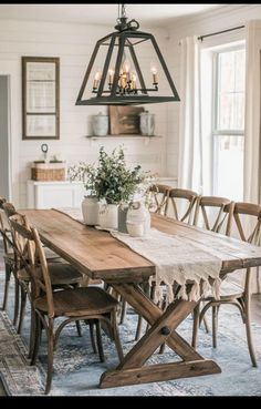 a dining room table with chairs and a potted plant on top of the table