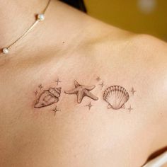 a woman's chest with three seashells and starfish tattoos on it