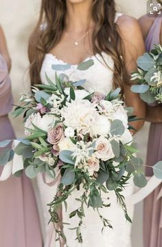 the bridesmaids are holding their bouquets with greenery and flowers on them