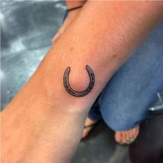 a small horseshoe tattoo on the wrist