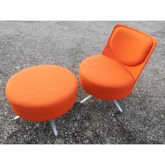 an orange chair and ottoman sitting on concrete