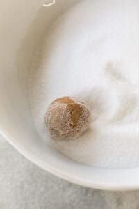 a bowl filled with sugar and powdered donut on top of a countertop