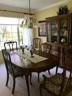 a dining room table with chairs and a china cabinet