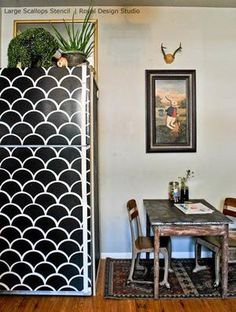 a room with a table, chairs and a tall black and white cabinet in it