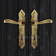 two golden door handles on a black wooden wall with wood planks in the background