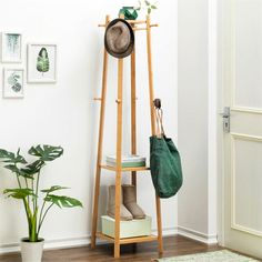 a wooden shelf with a hat and bag on it next to a potted plant